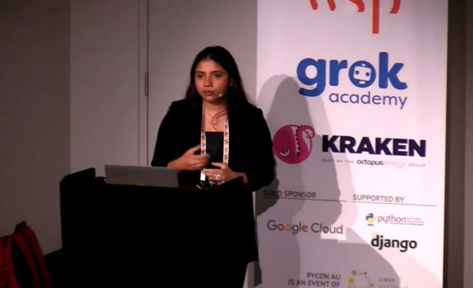 Swastika speaking at the podium at PyCon Australia