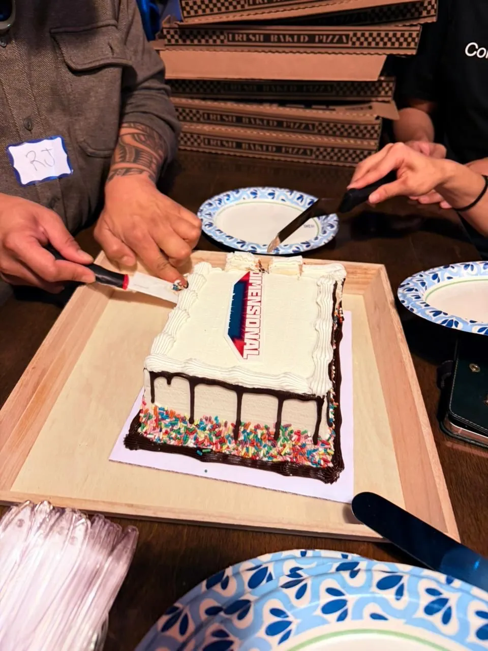 A Dimensional cake being cut at the event