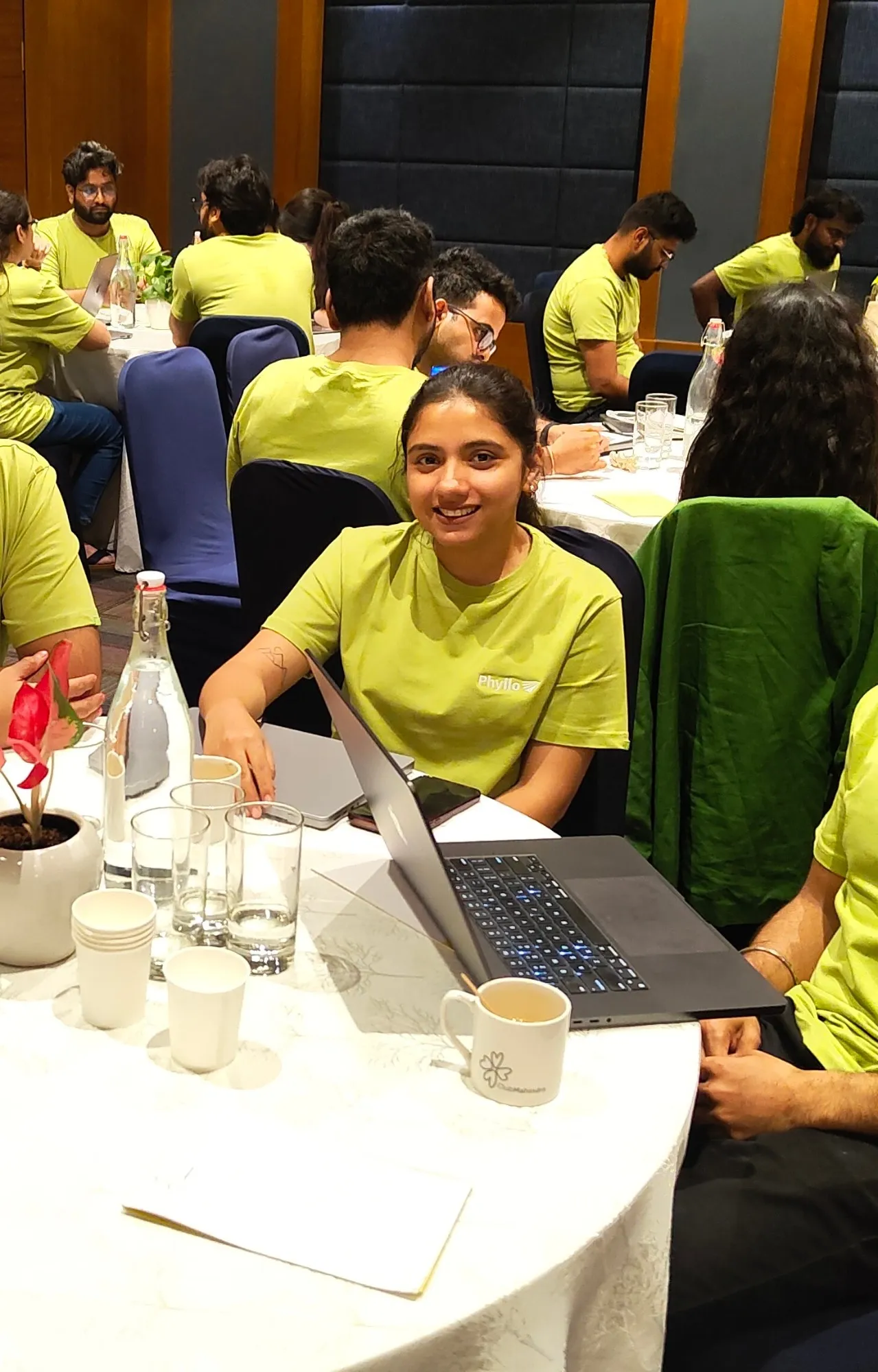 At a Phyllo team offsite, laptop open, everyone in matching green tees